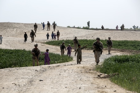 Afghan children follow Marine advisors with Task Force Southwest (TFSW) during a patrol to 6th Sub District Headquarters in Bost Kalay, Afghanistan, March 17, 2018. The movement allowed Marine advisors with TFSW to build rapport with their counterparts in the Afghan National Defense and Security Forces to enhance the unit’s train, advise and assist mission in Helmand Province. (U.S. Marine Corps photo by Sgt. Sean J. Berry)