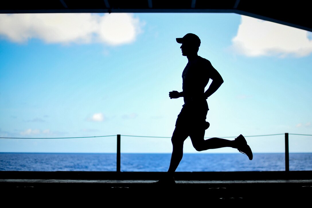 A sailor jogs in the hangar bay.