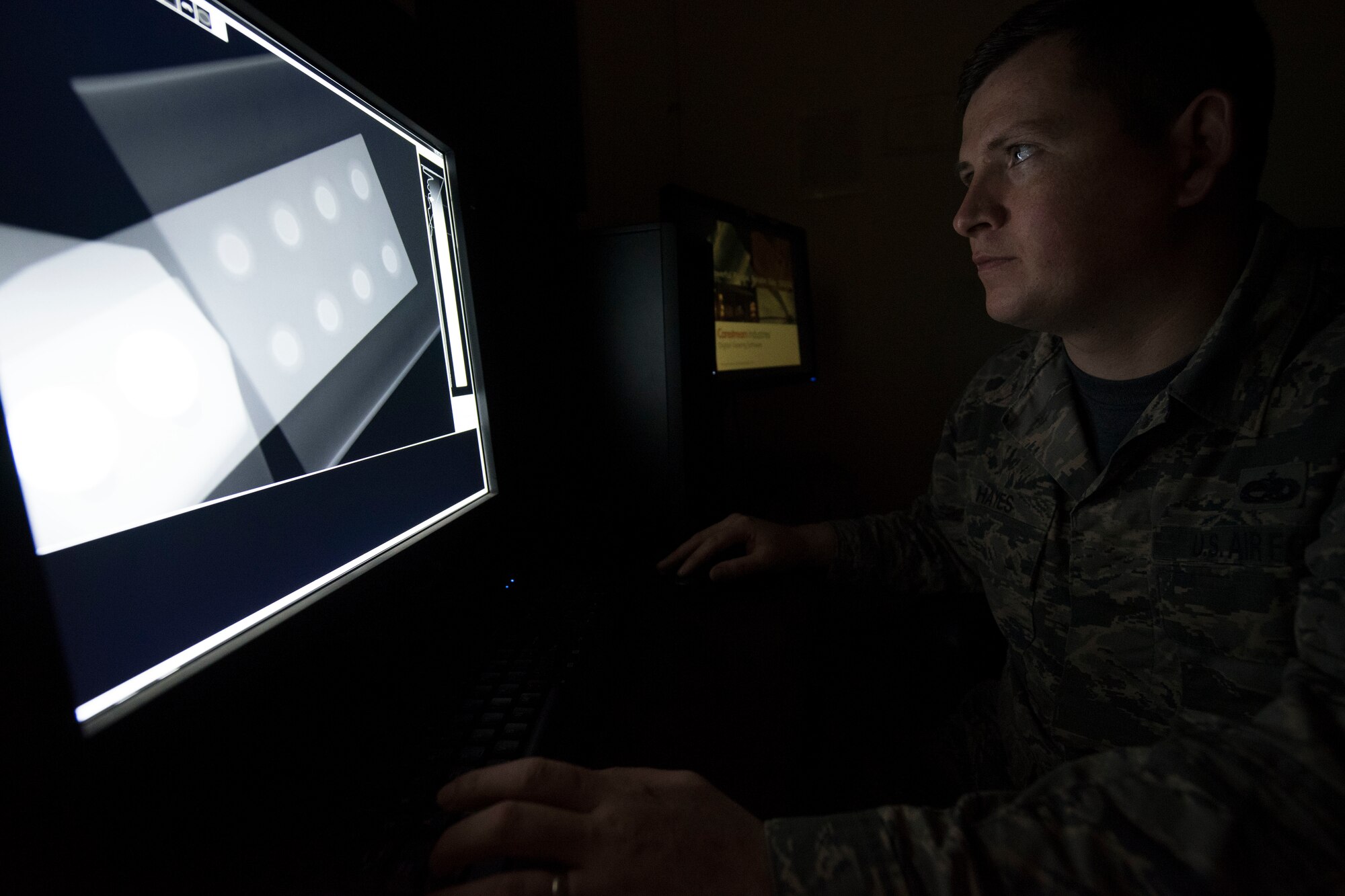 A man looks at a computer screen with an x-ray on it.