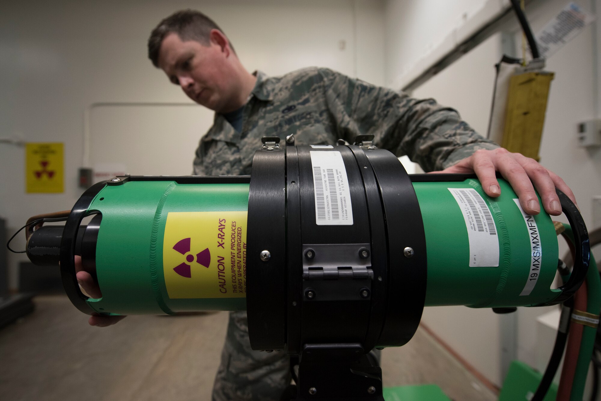 A man looks at a green x-ray device.