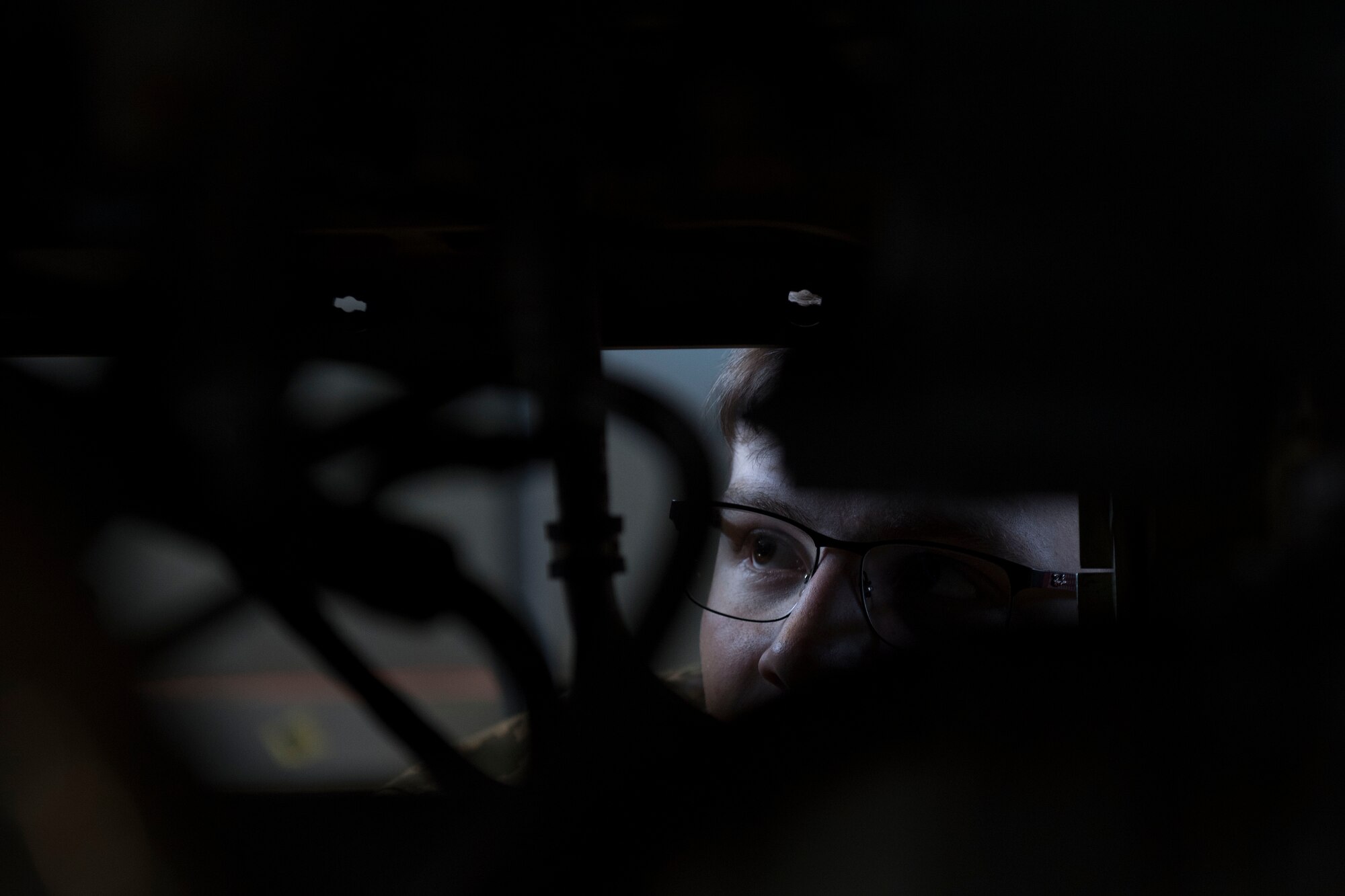 An Airmen looks at an aircraft part.