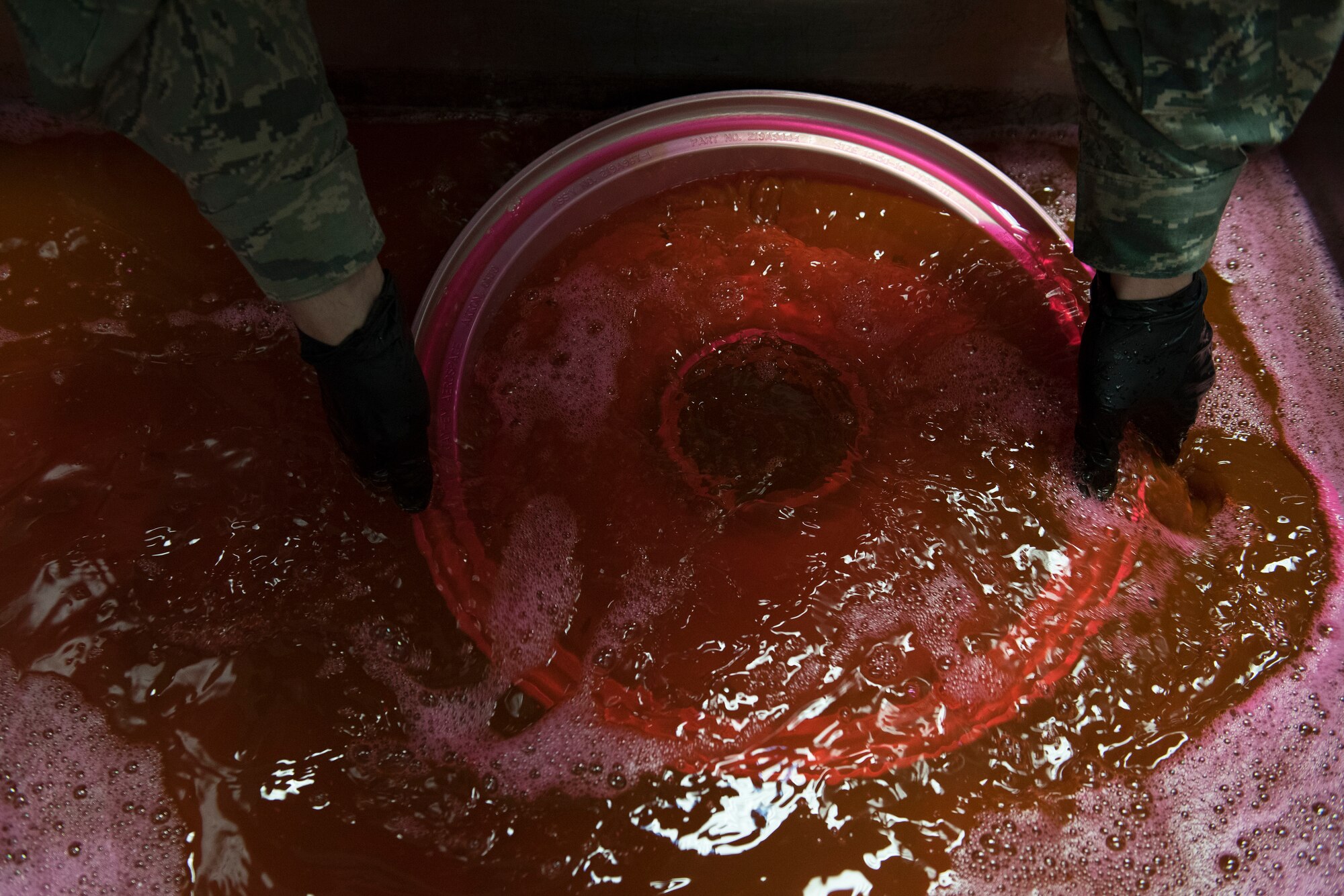 An aircraft wheel is dipped into red liquid.