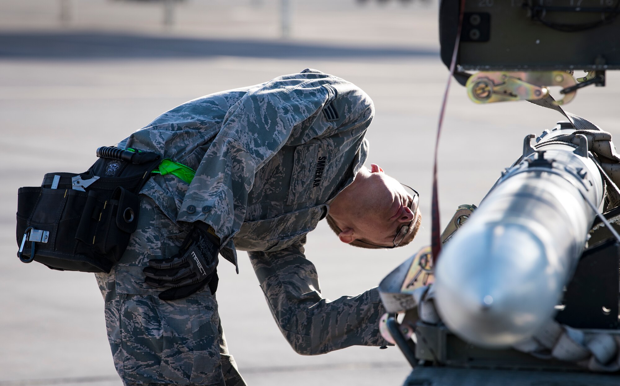 Senior Airman Travis Smrekar, 57th Aircraft Maintenance Squadron weapons loader, prepares a missile to be loaded during a load crew competition at Nellis Air Force Base, Nevada, April 13, 2018. The crews inspected, loaded, and secured two Mark 84 bombs and one AIM-120 AMRAAM onto their respective aircraft.(U.S. Air Force photo by Airman 1st Class Andrew D. Sarver)