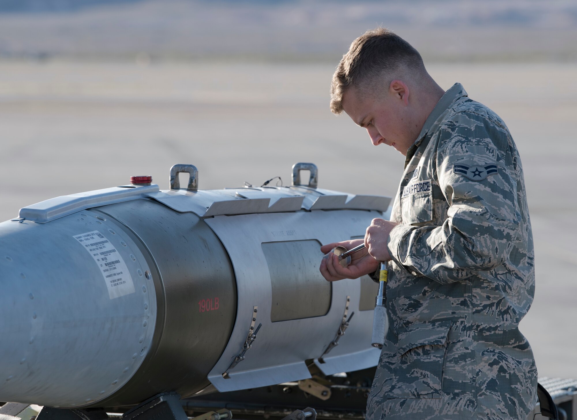 Airman 1st Class Ryan Henderson, 57th Aircraft Maintenance Squadron weapons loader, prepares a bomb to be loaded during a load crew competition at Nellis Air Force Base, Nevada, April 13, 2018. The competition challenges the teams' ability to load munitions on aircraft in an accurate, safe and timely manner.(U.S. Air Force photo by Airman 1st Class Andrew D. Sarver)