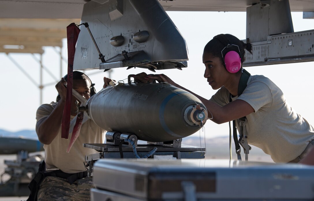 Senior Airman Wayne Right and Staff Sgt. Conswaila Jackson, 57th Aircraft Maintenance Squadron weapons loaders, load a bomb onto an F-16 Fighting Falcon fighter jet during a load crew competition at Nellis Air Force Base, Nevada, April 13, 2018. The crews inspected, loaded, and secured two Mark 84 bombs and one AIM-120 AMRAAM onto their respective aircraft.(U.S. Air Force photo by Airman 1st Class Andrew D. Sarver)