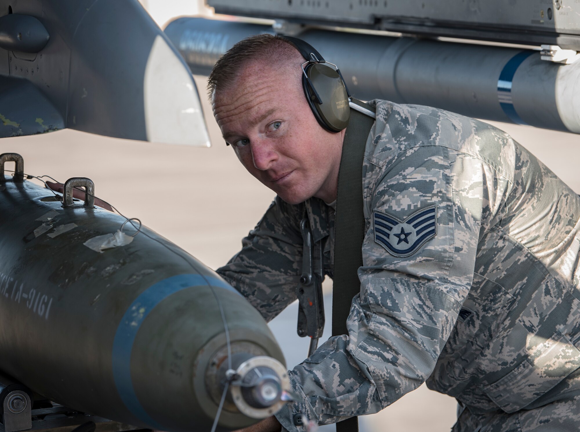 Staff Sgt. Shawn White, 57th Aircraft Maintenance Squadron weapons loader, loads a bomb onto an F-16 Fighting Falcon fighter jet during a load crew competition at Nellis Air Force Base, Nevada, April 13, 2018. The competition challenges the teams' ability to load munitions on aircraft in an accurate, safe and timely manner.(U.S. Air Force photo by Airman 1st Class Andrew D. Sarver)