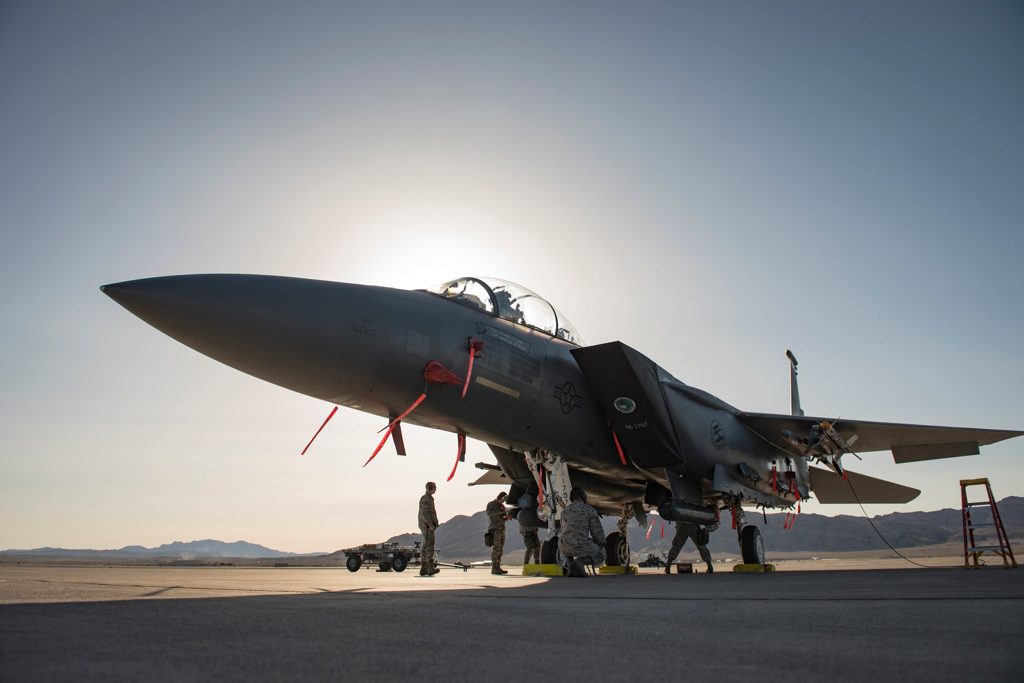 Airmen assigned to the 389th Aircraft Maintenance Unit, Mountain Home Air Force Base, Idaho, perform final checks on an F-15 Eagle fighter jet during a load crew competition at Nellis Air Force Base, Nevada, April 13, 2018. Each team consisted of three members who played a specific role in the competition to increase their team's success by working as one cohesive unit.(U.S. Air Force photo by Airman 1st Class Andrew D. Sarver)