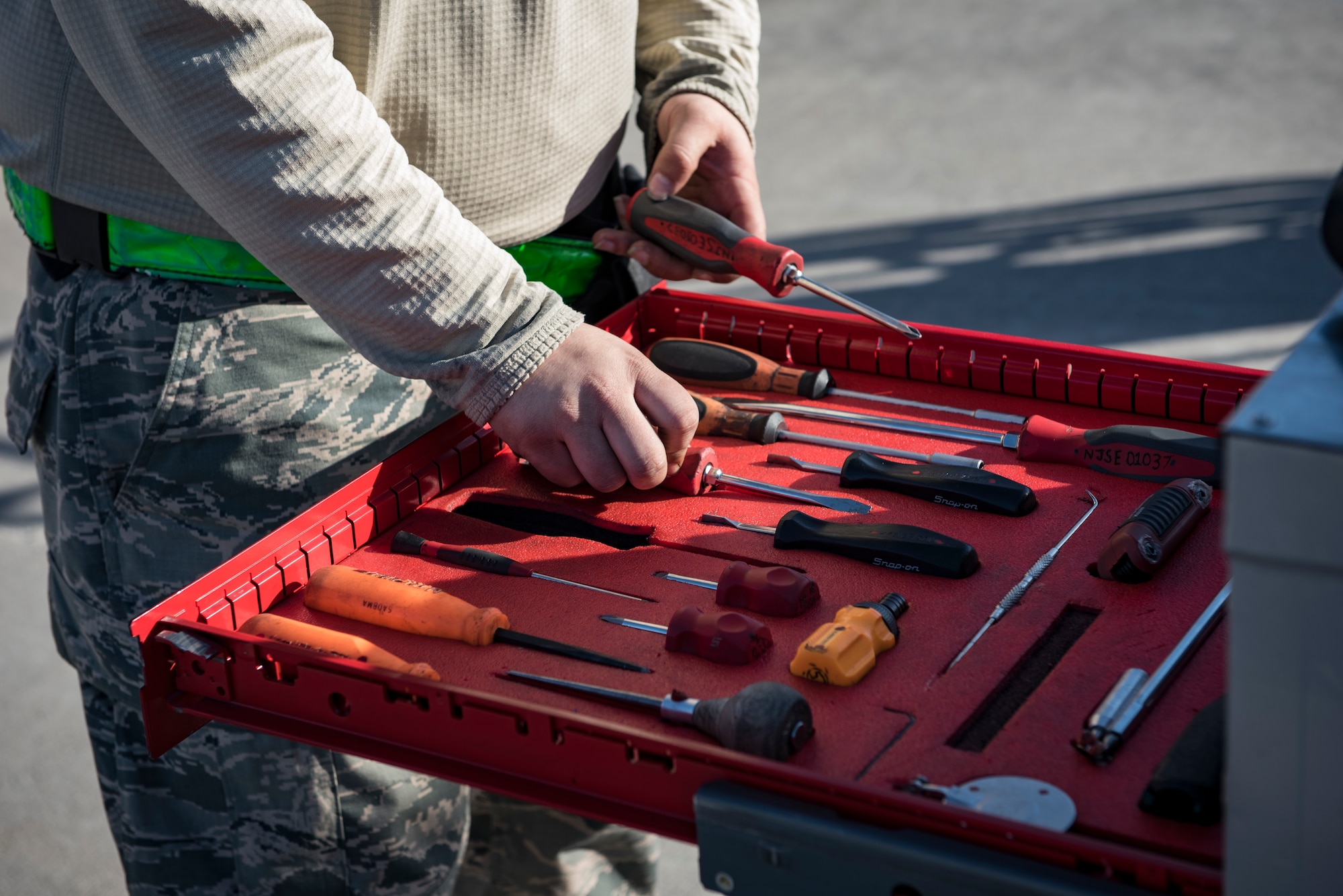 Senior Airman Austin Reynolds, 57th Aircraft Maintenance Squadron weapons loader, picks up a screwdriver during a load crew competition at Nellis Air Force Base, Nevada, April 13, 2018. The crews inspected, loaded, and secured two Mark 84 bombs and one AIM-120 AMRAAM onto their respective aircraft.(U.S. Air Force photo by Airman 1st Class Andrew D. Sarver)