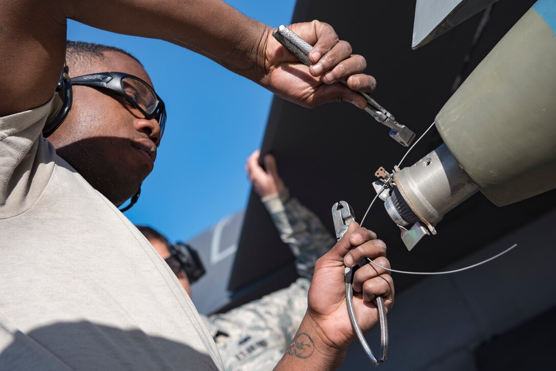 Senior Airman Wayne Right, 57th Aircraft Maintenance Squadron weapons loader prepares a bomb on an F-16 Fighting Falcon fighter jet during a load crew competition at Nellis Air Force Base, Nevada, April 13, 2018. Each team consisted of three members who played a specific role in the competition to increase their teams success by working as one cohesive unit.(U.S. Air Force photo by Airman 1st Class Andrew D. Sarver)