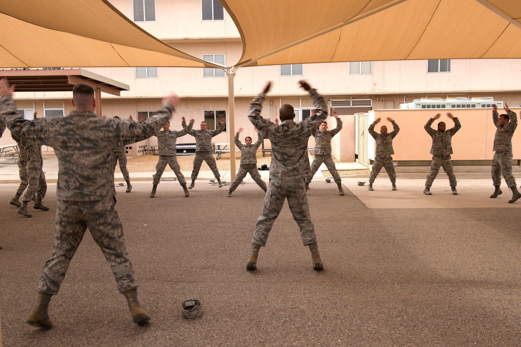 Members of Honor Guard units from Luke Air Force Base, Ariz., and other local areas, perform jumping jacks under the direction of instructors from the official U.S. Air Force Honor Guard April 16, 2018. The Air Force Honor Guard visited Luke as part of an effort to enrich the skill sets of localized Honor Guard units at individual bases. (U.S. Air Force photo by Senior Airman Ridge Shan)