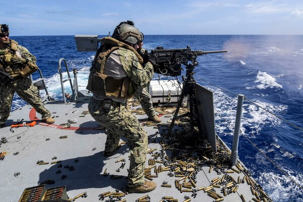 Navy Petty Officer 2nd Class Michael DeCesare fires an M2 machine gun aboard a Mark VI patrol boat during a crew-served weapons qualification in the Philippine Sea, April 12, 2018. DeCesare is assigned to Coastal Riverine Squadron 4. Navy photo by Petty Officer 1st Class Cory Asato