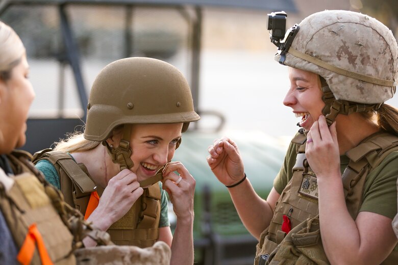 Brandi Pompa, wife of Sgt. Isaac Pompa, scouts, Alpha Company, 1st Tank Battlion, and Katherine Shelton, wife of Cpl. Chad Shelton, scouts, Alpha Company, 1st Tanks, adjust their kevlar helmets during the unit’s Jane Wayne Spouse Appreciation Day aboard the Marine Corps Air Ground Combat Center, Twentynine Palms, Calif., April 3, 2018. The purpose of the event is to build resiliency in spiritual well being, the will to fight and a strong home life for the 1st Tanks Marines and their families. (U.S. Marine Corps photo by Lance Cpl. Rachel K. Porter)