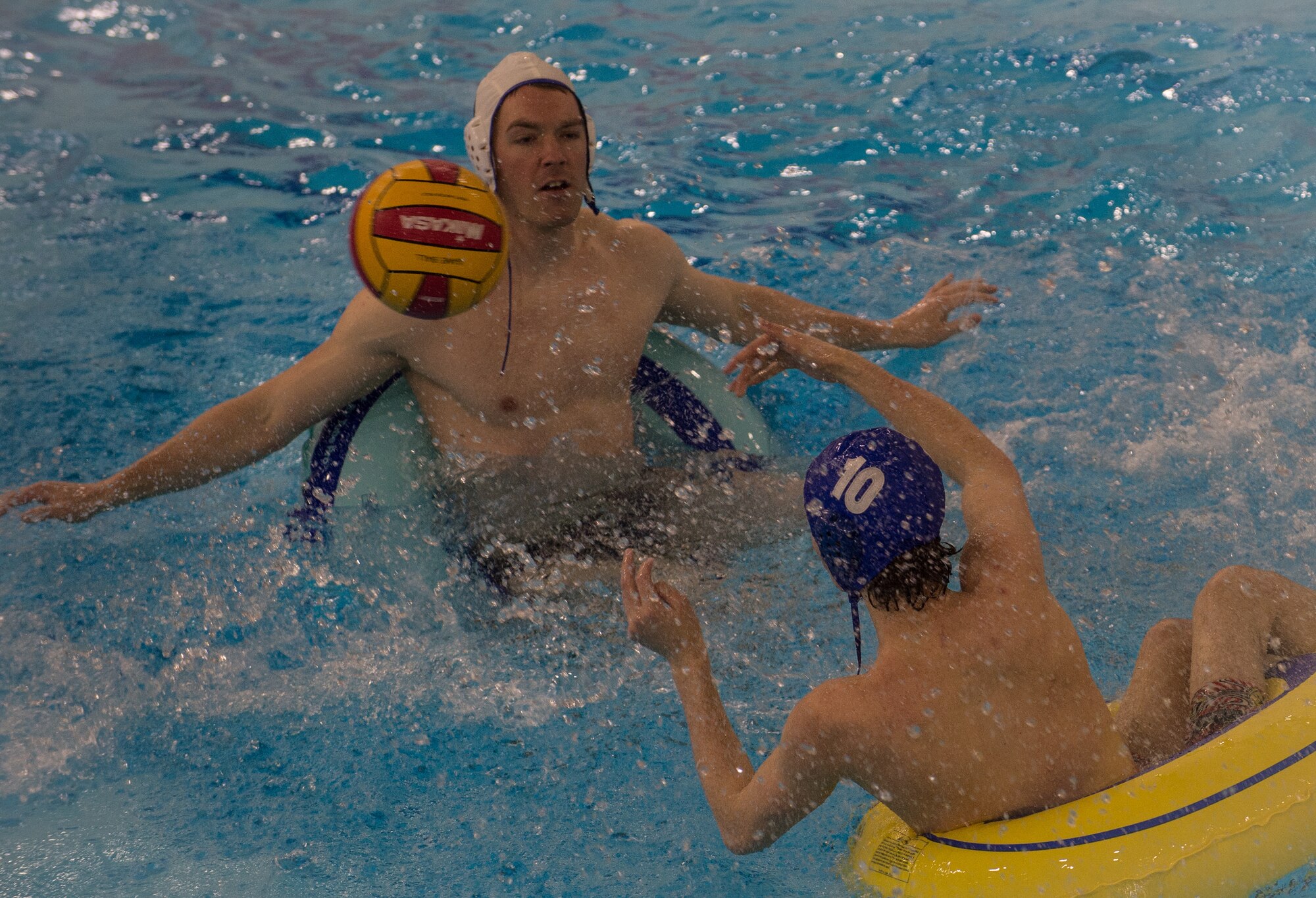 Military members and affiliates participate in an intramural game of water polo on inner tubes at the Buckner Physical Fitness Center on Joint Base Elmendorf-Richardson, Alaska, April 12, 2018. The fitness center offers a total of 18 intramural sports throughout the year, open to military members, family members, Department of Defense civilians and affiliates 18 years and older.