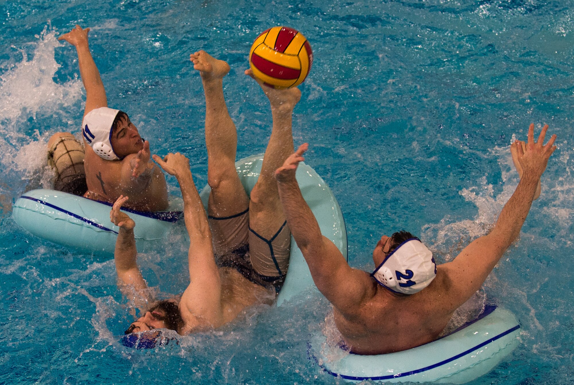 Military members and affiliates participate in an intramural game of water polo on inner tubes at the Buckner Physical Fitness Center on Joint Base Elmendorf-Richardson, Alaska, April 12, 2018. The fitness center offers a total of 18 intramural sports throughout the year, open to military members, family members, Department of Defense civilians and affiliates 18 years and older.