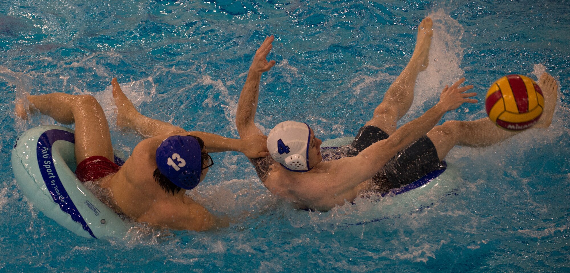 Military members and affiliates participate in an intramural game of water polo on inner tubes at the Buckner Physical Fitness Center on Joint Base Elmendorf-Richardson, Alaska, April 12, 2018. The fitness center offers a total of 18 intramural sports throughout the year, open to military members, family members, Department of Defense civilians and affiliates 18 years and older.