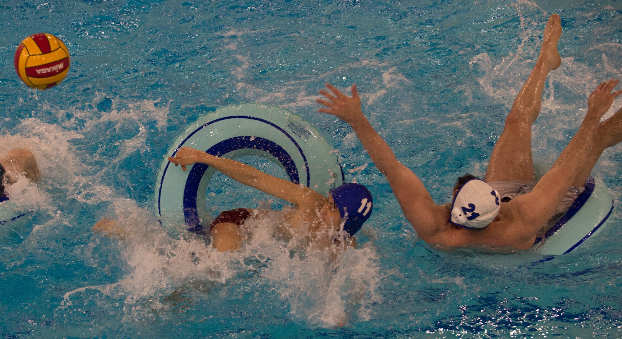 Military members and affiliates participate in an intramural game of water polo on inner tubes at the Buckner Physical Fitness Center on Joint Base Elmendorf-Richardson, Alaska, April 12, 2018. The fitness center offers a total of 18 intramural sports throughout the year, open to military members, family members, Department of Defense civilians and affiliates 18 years and older.