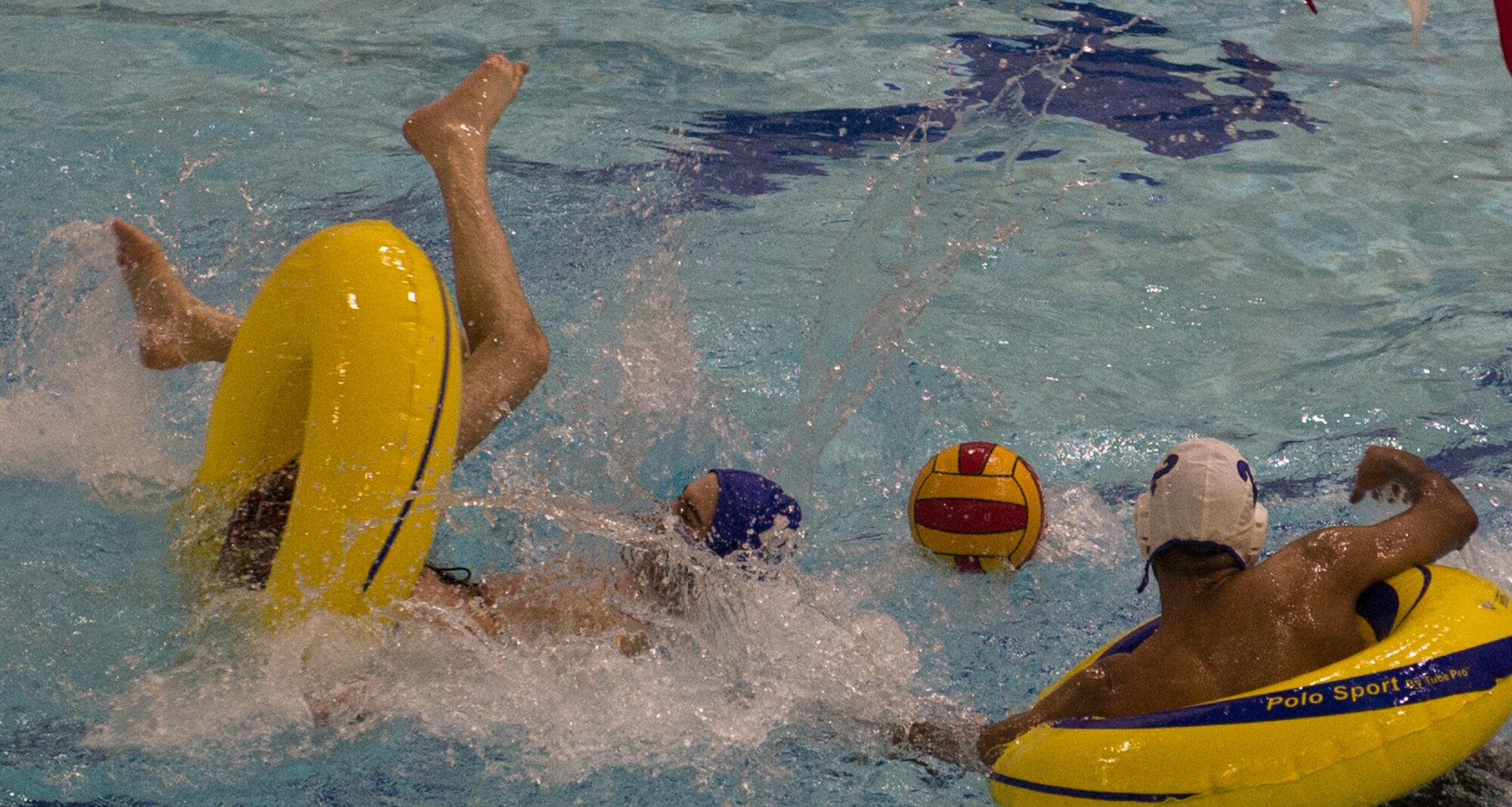 Military members and affiliates participate in an intramural game of water polo on inner tubes at the Buckner Physical Fitness Center on Joint Base Elmendorf-Richardson, Alaska, April 12, 2018. The fitness center offers a total of 18 intramural sports throughout the year, open to military members, family members, Department of Defense civilians and affiliates 18 years and older.
