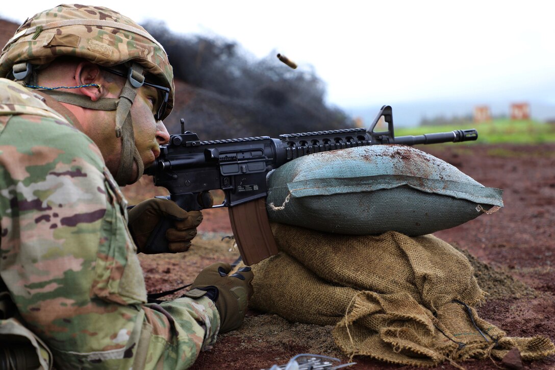 A soldier fires a rifle at targets.
