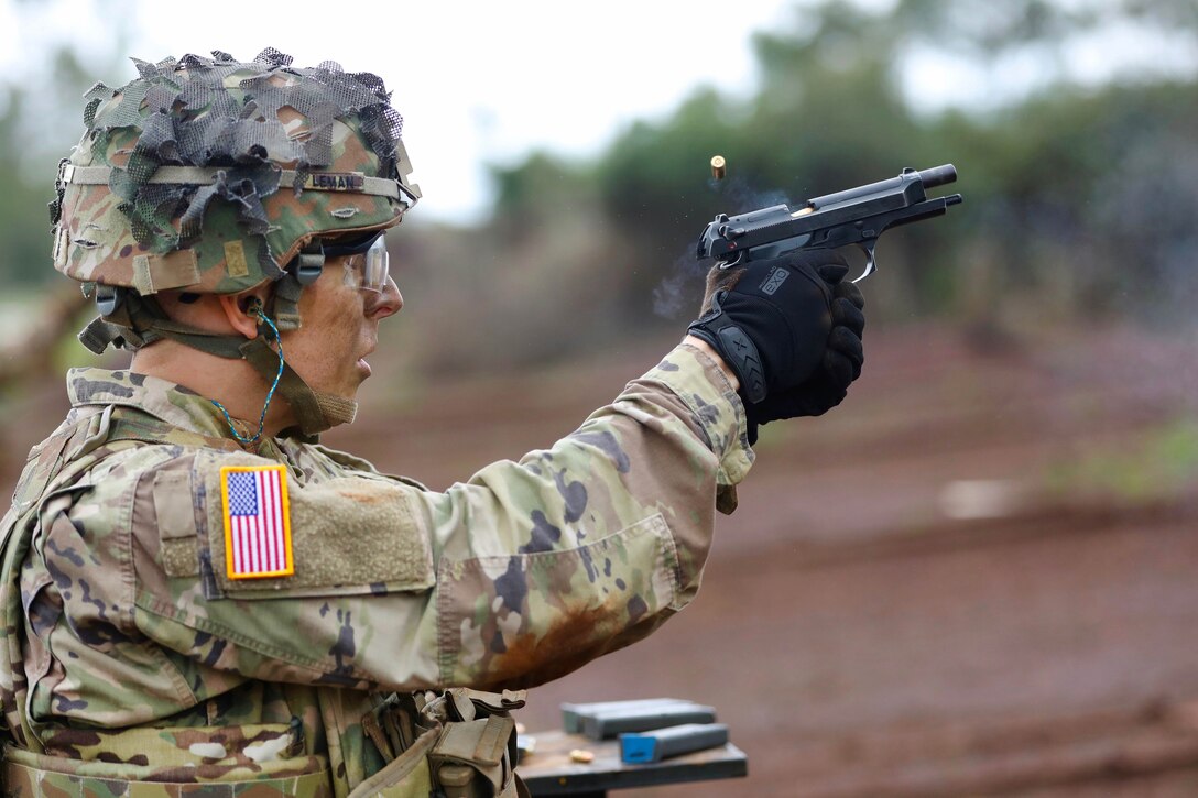 A soldier fires a 9 mm pistol round at a target.