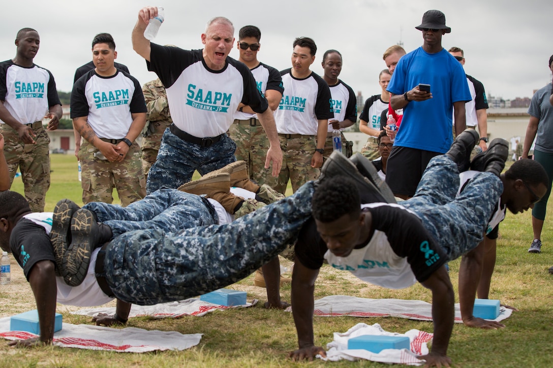 Sailors compete in a pushup event.