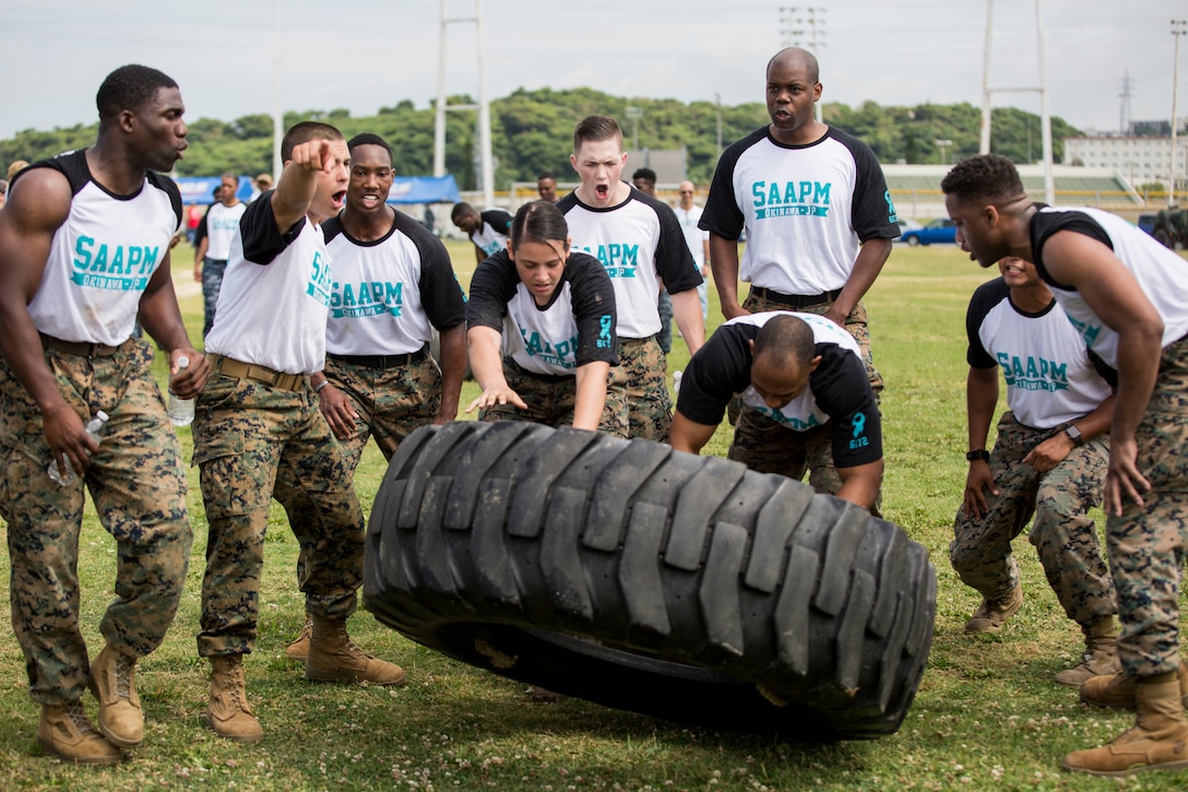 Marines cheer on their teammates during a tire flipping competition.