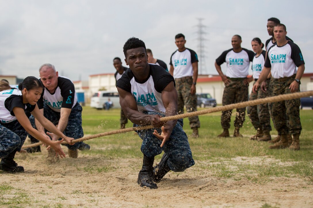 Sailors participate in a tug of war.