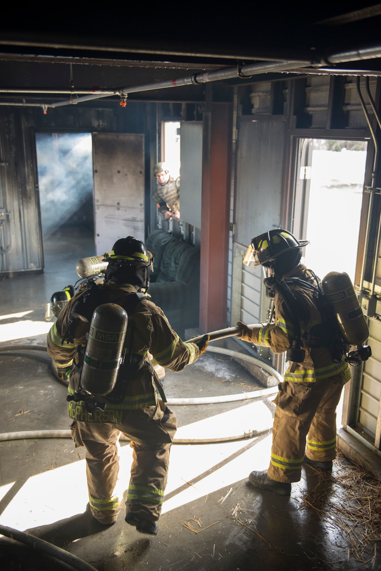 Air Force Staff Sgt. Mathew McPherson and Airmen 1st Class Brittney Jordan, both are 673d Civil Engineer Squadron Fire and Emergency Service driver/operators, pass hosing to each other during exercise Polar Force 18-5 at Joint Base Elmendorf-Richardson, Alaska, April 11, 2018. Throughout the routine training exercise, Airmen donned Mission Oriented Protective Posture gear while completing various mission-related tasks to test their capabilities in challenging circumstances.