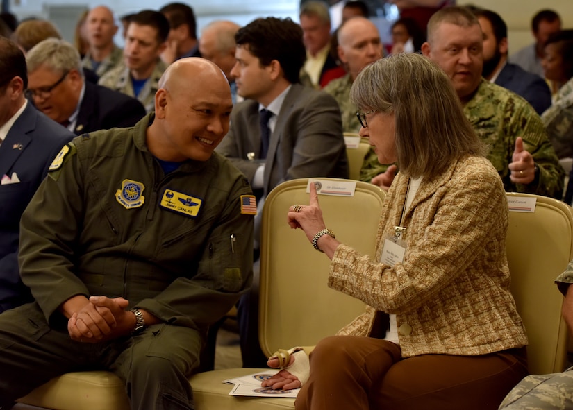 Col. Jimmy Canlas, left, commander of the 437th Airlift Wing, speaks with his new honorary commander Town of North Mayor Patty Carson, right, during the Honorary Commander Induction Ceremony April 13, 2018, at the Air Base Club.