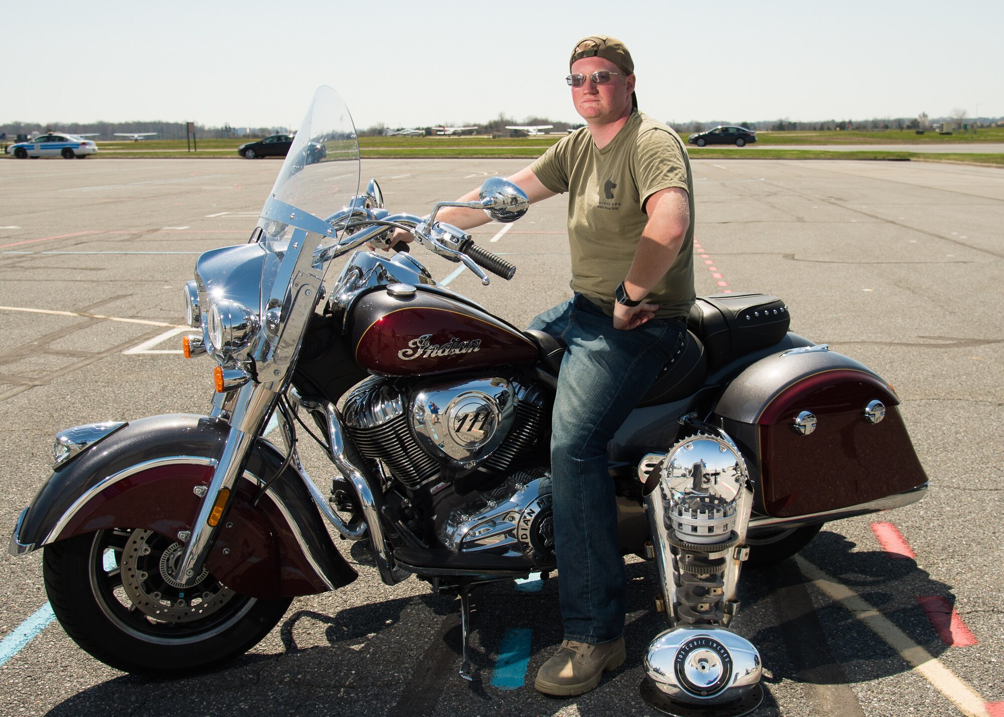 Senior Airman Ronald Naugle, 436th Aerial Port Squadron special handling processor, shows off his motorcycle and trophy during Motorcycle Safety Day April 13, 2018, at Dover Air Force Base, Del. Naugle’s 2017 Indian was selected from about 120 motorcycles as the best overall bike. (U.S. Air Force photo by Mauricio Campino)