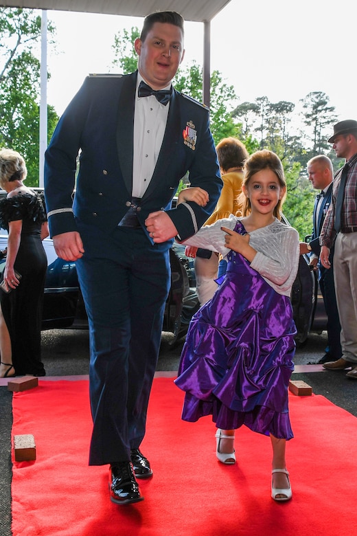 U.S. Air Force 2nd Lt. James Golden, the executive officer of the 343rd Bomb Squadron, Barksdale Air Force Base, Louisiana, escorts children into the El Karubah Shriners’ Memories in Wonderland Ball April 14, at the Shriners’ Clubhouse in Shreveport, La., April 14, 2018.