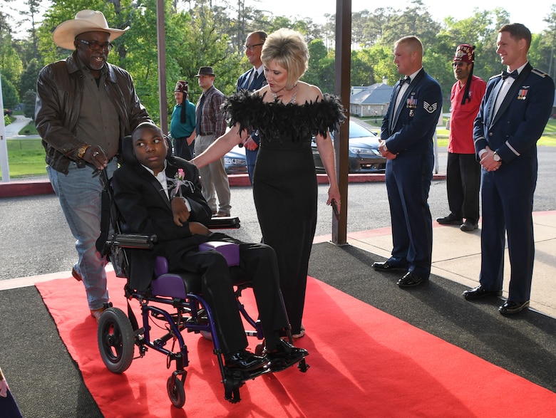Jayne Smith provides and escort down the red carpet at the El Karubah Shriners’ Memories in Wonderland Ball at the Shriners’ Clubhouse in Shreveport, Louisiana, April 14, 2018.