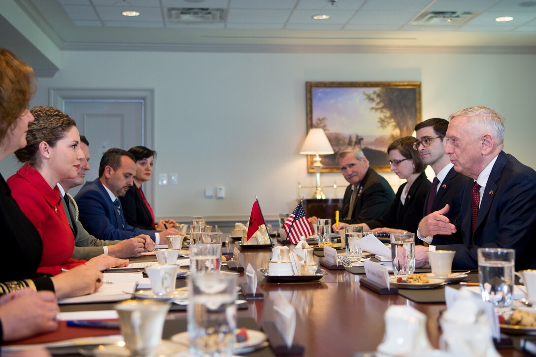 Defense Secretary James N. Mattis sits at a table with other people.