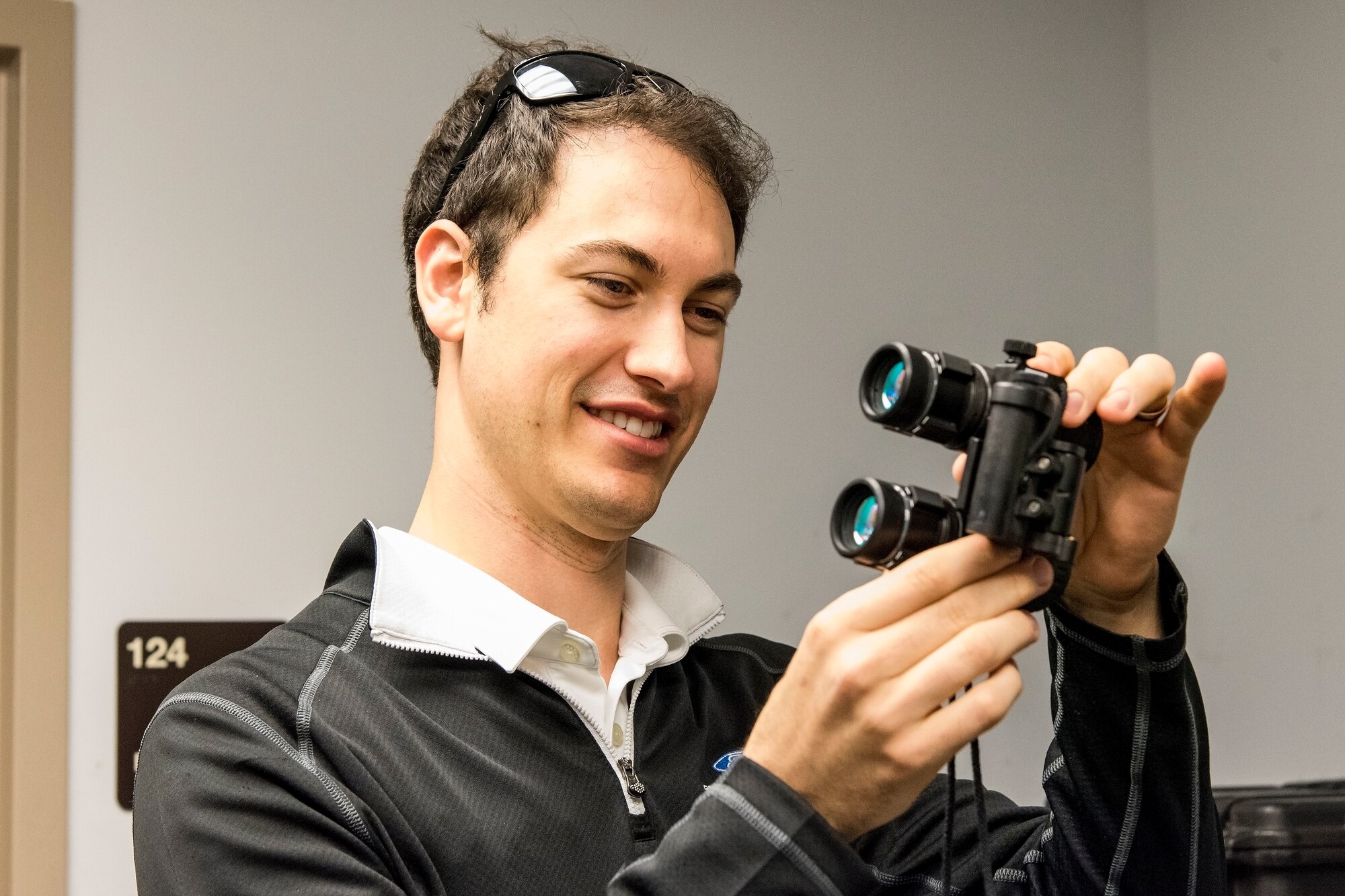 Joey Logano, driver of the No. 22 Ford in the Monster Energy NASCAR Cup Series, looks at a pair of night vision goggles while touring the 436th Operations Support Squadron aircrew flight equipment facilities April 11, 2018, at Dover Air Force Base, Del. Logano is scheduled to compete in the “AAA 400 Drive for Autism” Monster Cup Series race on Sunday, May 6 at Dover International Speedway. (U.S. Air Force photo by Roland Balik)