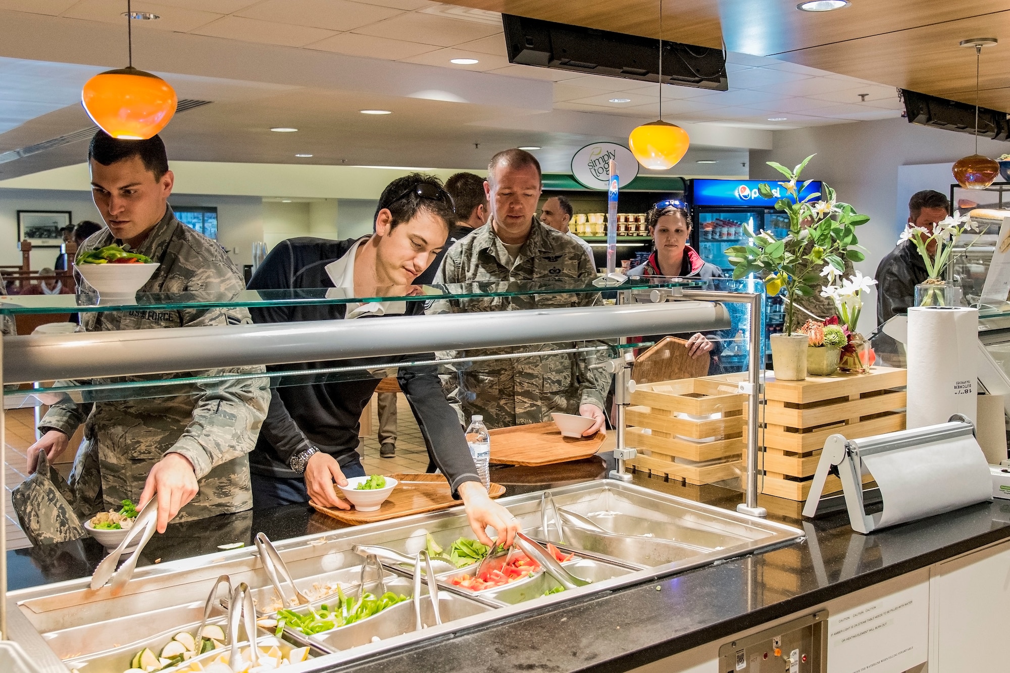 Joey Logano, driver of the No. 22 Ford in the Monster Energy NASCAR Cup Series, followed by Tech. Sgt. Jerry Ivey, 436th Airlift Wing Command Post senior emergency action controller, go through the food line at the Patterson Dining Facility April 11, 2018, on Dover Air Force Base, Del. Logano had lunch with Team Dover members during his five-hour tour of the base. (U.S. Air Force photo by Roland Balik)