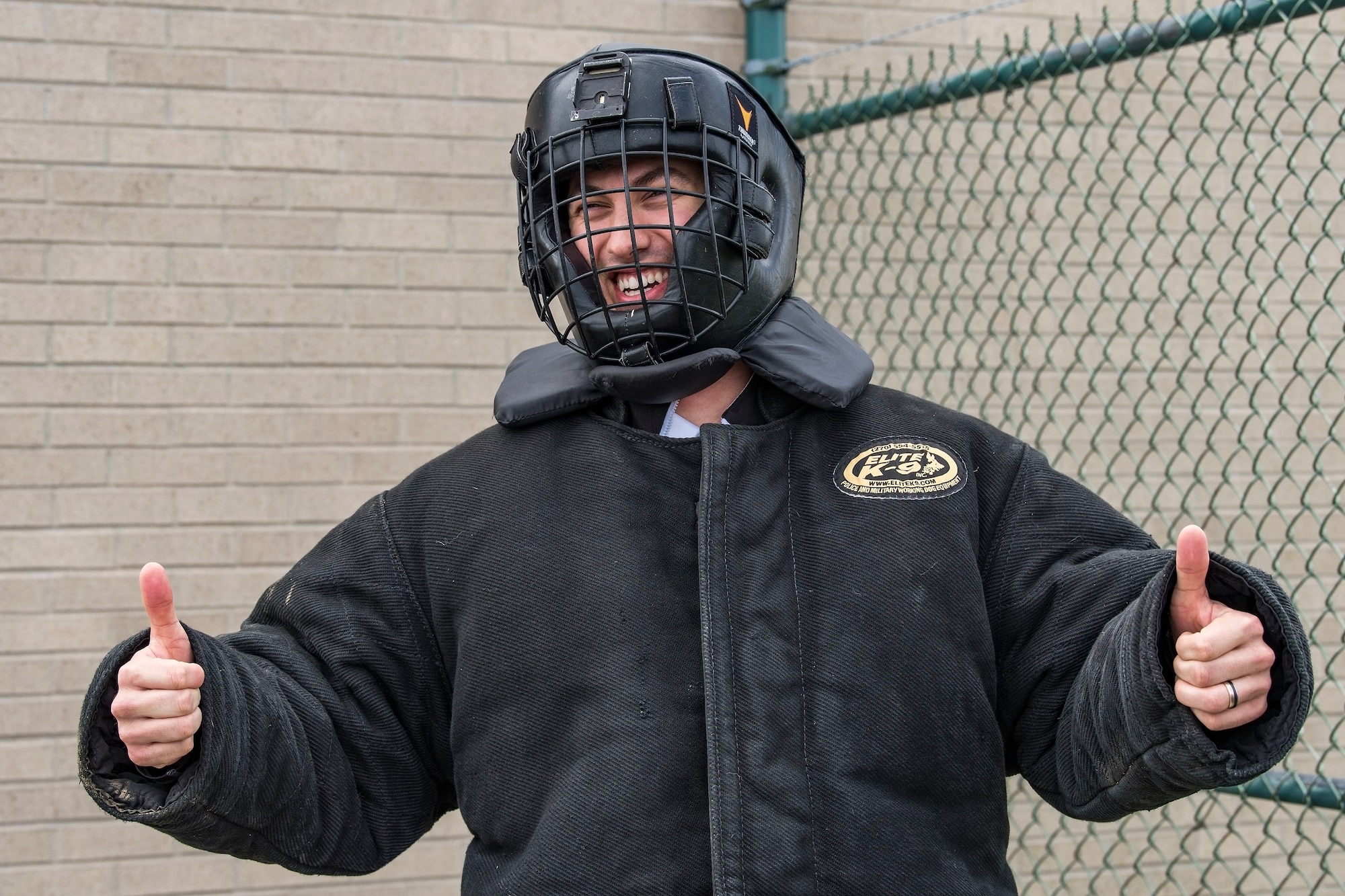 Joey Logano, driver of the No. 22 Ford in the Monster Energy NASCAR Cup Series, gives the “thumbs up” sign as he prepares to enter the 436th Security Forces Squadron military working dog training area April 11, 2018, at Dover Air Force Base, Del. Logano donned the protective bite suit in preparation for a demonstration involving him and Karlo, an 80-pound Belgian Malinois. (U.S. Air Force photo by Roland Balik)