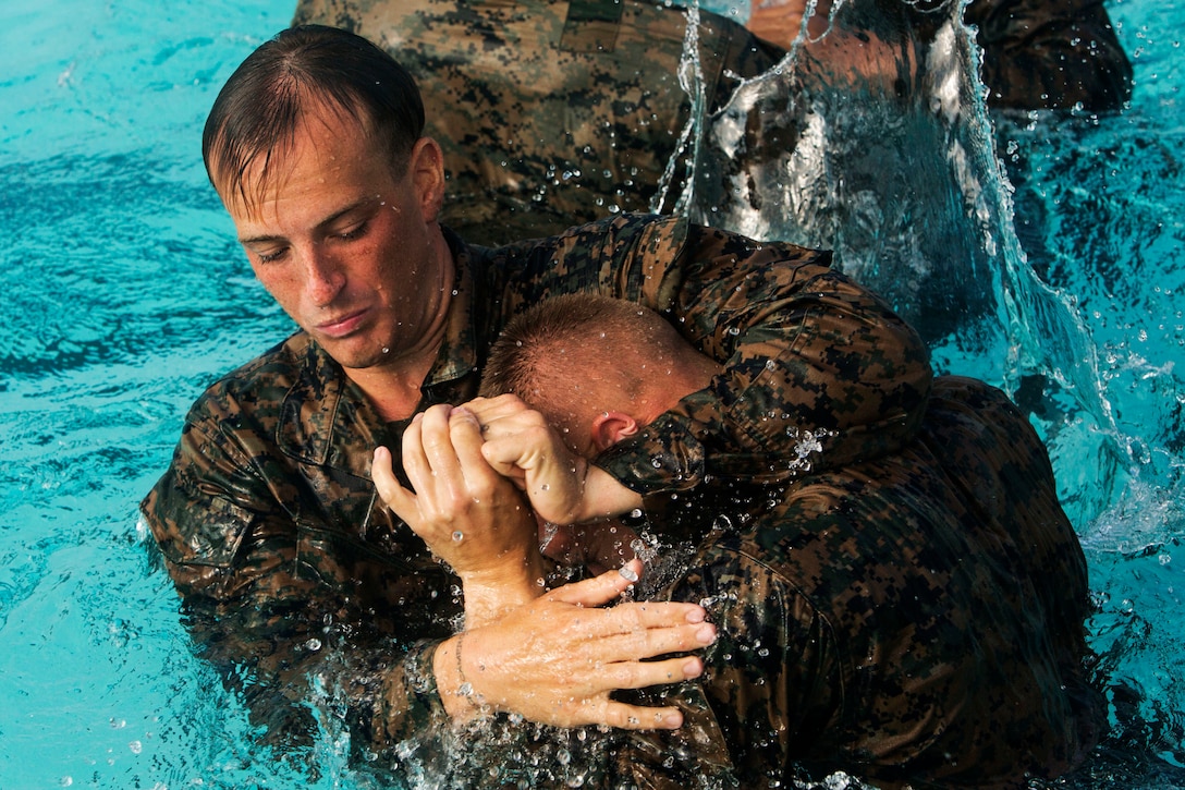 A Marine puts another Marine in a headlock.