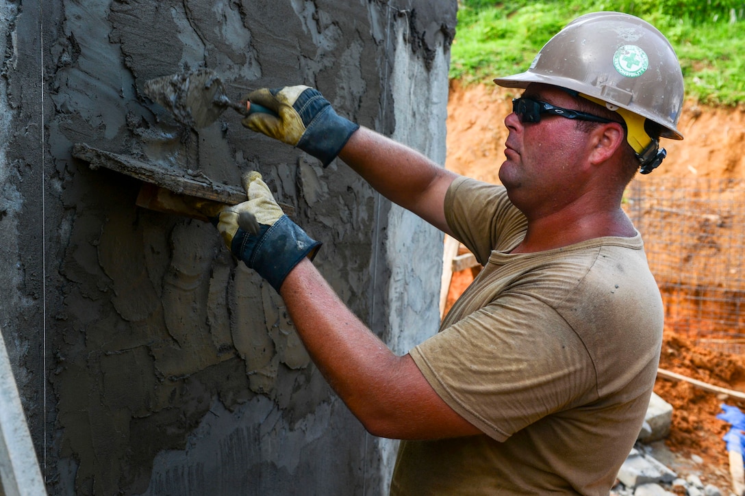 Soldier mixes stucco for construction project.