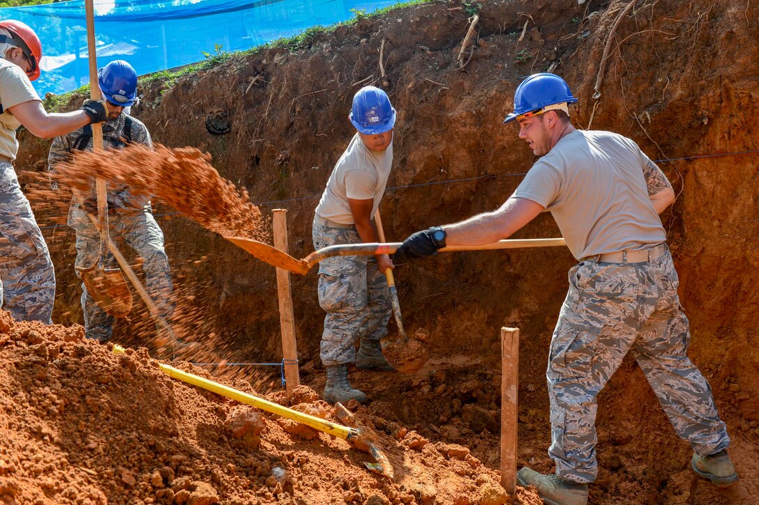 Troops dig a retaining wall trench.