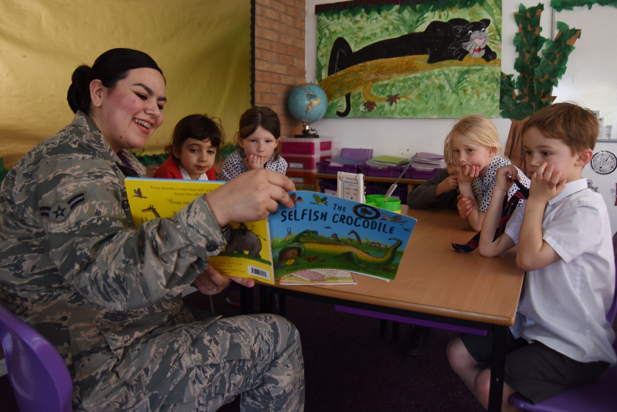 Airman 1st Class Sirinity Berganza-Campos, 48th Dental Squadron dental assistant, reads to a group of children at Brookes Cambridge school in Bury St. Edmunds, England, April 17, 2018. Six Liberty Wing Airmen visited the school to read with the students and build relationships in the community. (U.S. Air Force photo/Senior Airman Abby L. Finkel)