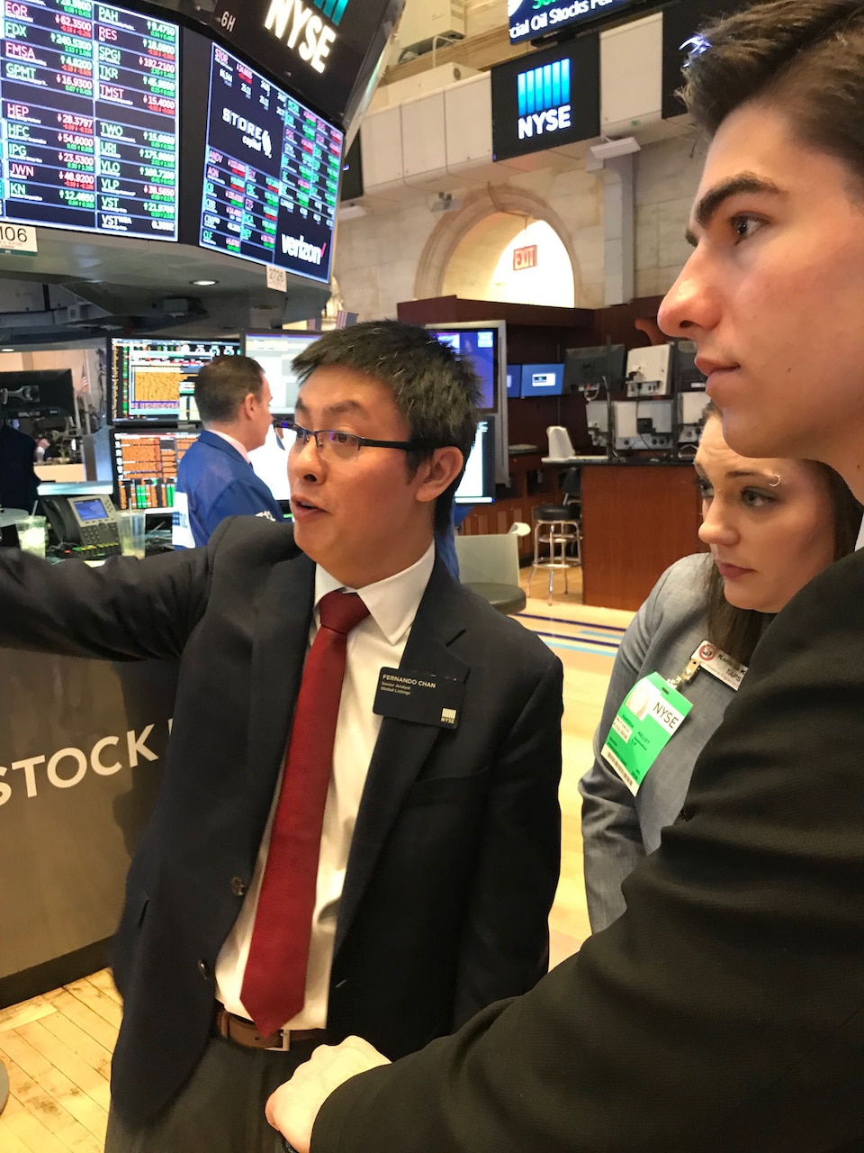 A New York Stock Exchange executive explains operations to two Gold Star children at the opening bell in New York City, April 12, 2018. The Tragedy Assistance Program for Survivors provided the opportunity for young adults who lost a parent who was serving on active duty in the military to meet with professionals in careers they hope to pursue. Courtesy photo
