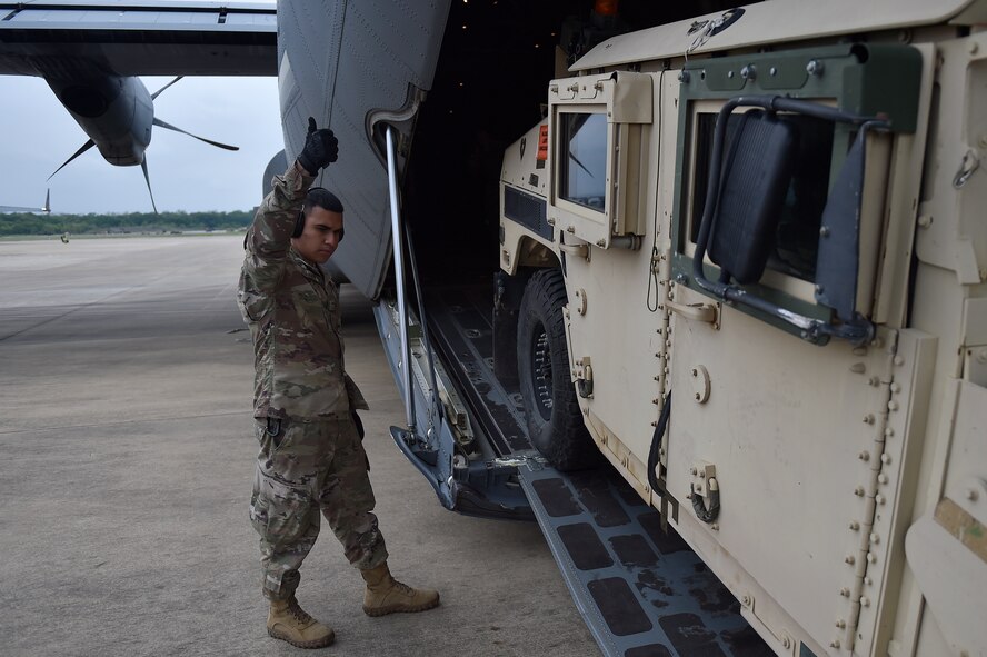 Senior Airman Edwin Suarez, 921st Contingency Response Squadron aerial porter, guides an Army Humvee onto a C-130 Hercules aircraft during the Joint Readiness Training Center exercise, April 8, 2018, at the Alexandria International Airport, La. Contingency Response Airmen conducted joint training with Soldiers from the 2nd Brigade Combat Team, 82nd Airborne Division, providing direct air-land support for safe and efficient airfield operations. (U.S. Air Force photo by Tech. Sgt. Liliana Moreno/Released)