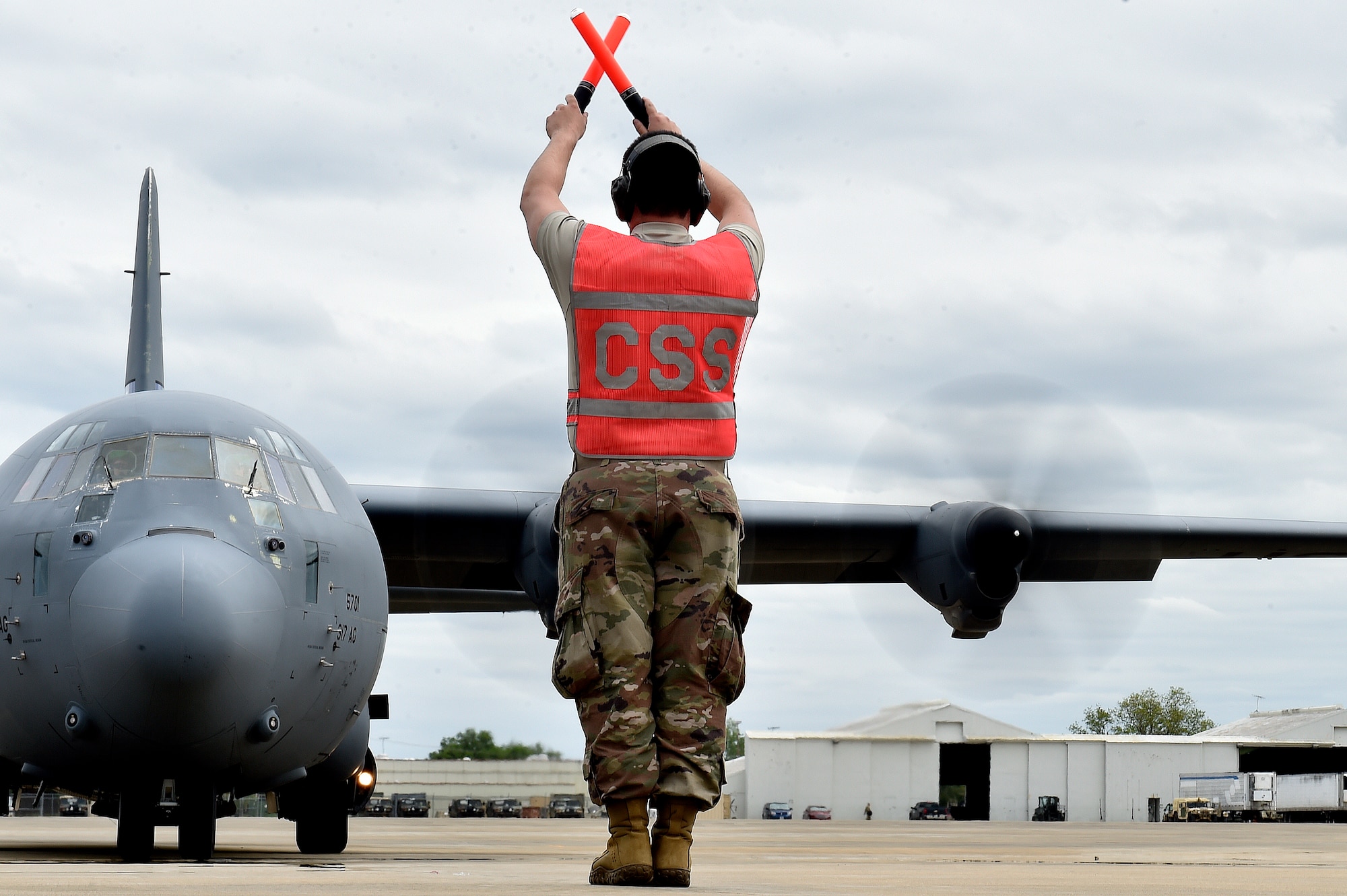 Senior Airman Adan Solis, 921st Contingency Response Squadron aircraft maintainer, marshals a C-130 Hercules aircraft during the Joint Readiness Training Center exercise, April 9, 2018, at the Alexandria International Airport, La. Contingency Response Airmen conducted joint training with Soldiers from the 2nd Brigade Combat Team, 82nd Airborne Division, providing direct air-land support for safe and efficient airfield operations. (U.S. Air Force photo by Tech. Sgt. Liliana Moreno/Released)