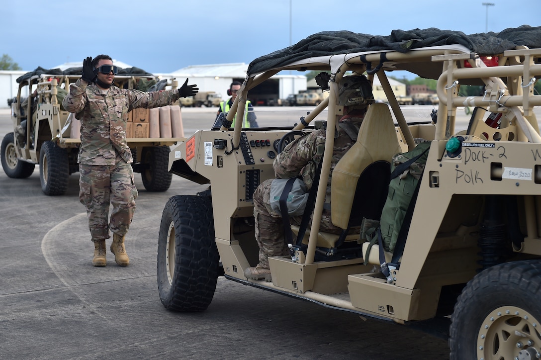 Tech. Sgt. Daray Davis, 921st Contingency Response Squadron aerial porter, directs the positioning of an Army vehicle onto a C-130 Hercules aircraft during the Joint Readiness Training Center exercise, April 9, 2018, at the Alexandria International Airport, La. Contingency Response Airmen conducted joint training with Soldiers from the 2nd Brigade Combat Team, 82nd Airborne Division, providing direct air-land support for safe and efficient airfield operations. (U.S. Air Force photo by Tech. Sgt. Liliana Moreno/Released)