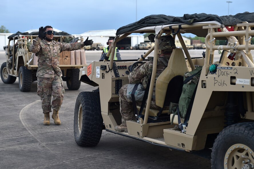 Tech. Sgt. Daray Davis, 921st Contingency Response Squadron aerial porter, directs the positioning of an Army vehicle onto a C-130 Hercules aircraft during the Joint Readiness Training Center exercise, April 9, 2018, at the Alexandria International Airport, La. Contingency Response Airmen conducted joint training with Soldiers from the 2nd Brigade Combat Team, 82nd Airborne Division, providing direct air-land support for safe and efficient airfield operations. (U.S. Air Force photo by Tech. Sgt. Liliana Moreno/Released)