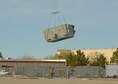 A new cooling unit is lifted off a parking lot by a helicopter to be placed on the roof of Bldg. 1600 April 7. (U.S. Air Force photo by Kenji Thuloweit)