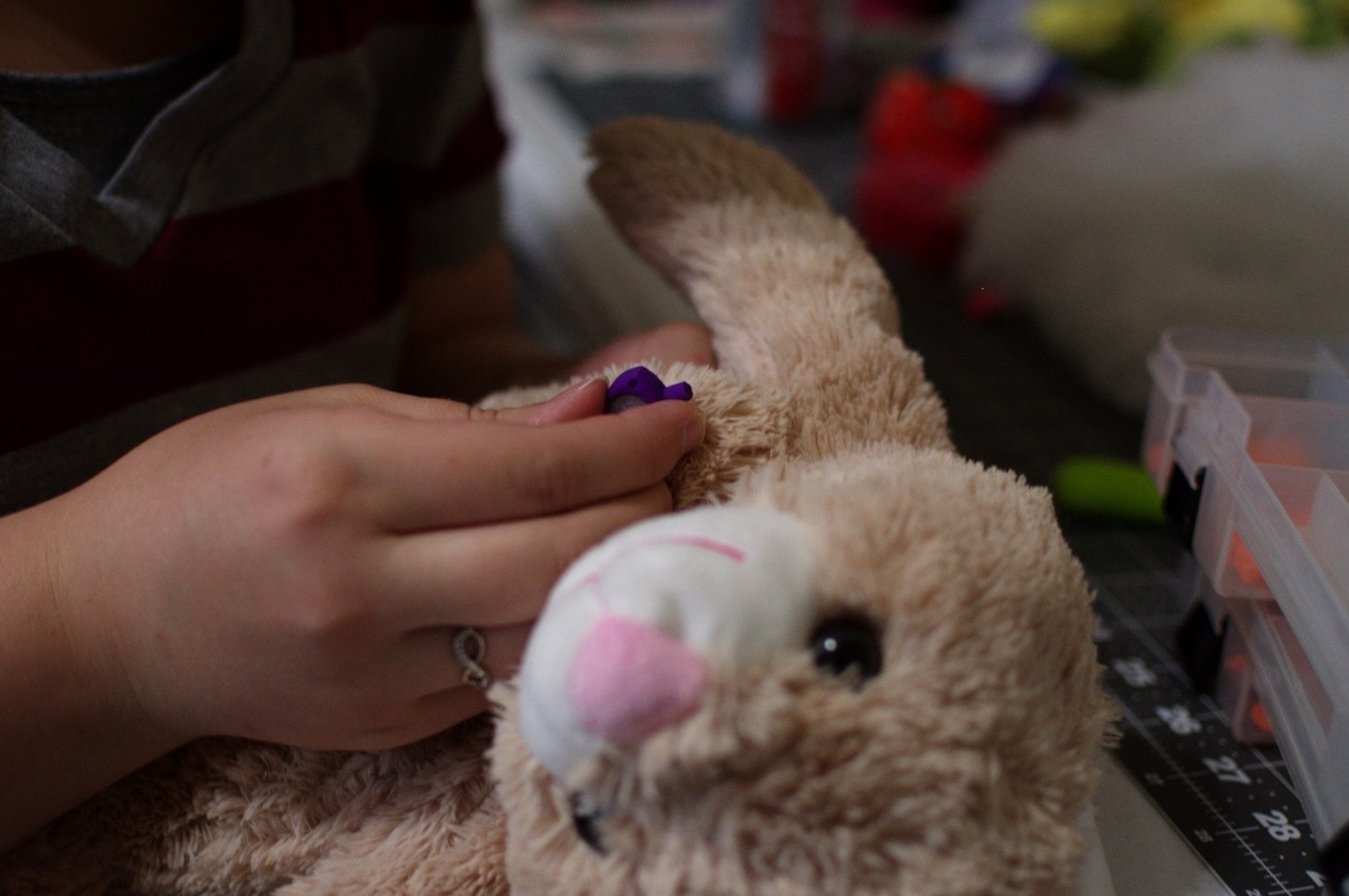 Kortni Kulikowski sews a toy gastrostomy tube onto a stuffed rabbit that her husband, Capt. Jeremy Kulikowski, Air Force Life Cycle Management Center cyber mobile command and control systems officer, 3-D printed at their home, April 12, 2018. After their daughter Kambri was diagnosed with duplication syndrome in 2017, Jeremy and Kortni were inspired to create these stuffed animals and donate about 60 of them to Memorial Hospital in Colorado Springs, where Kambri was treated.  (U.S. Air Force photo by Audrey Jensen)