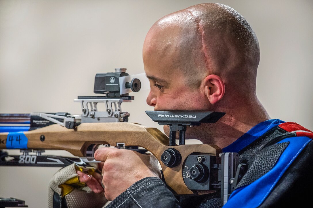 An airman aims a firearm.