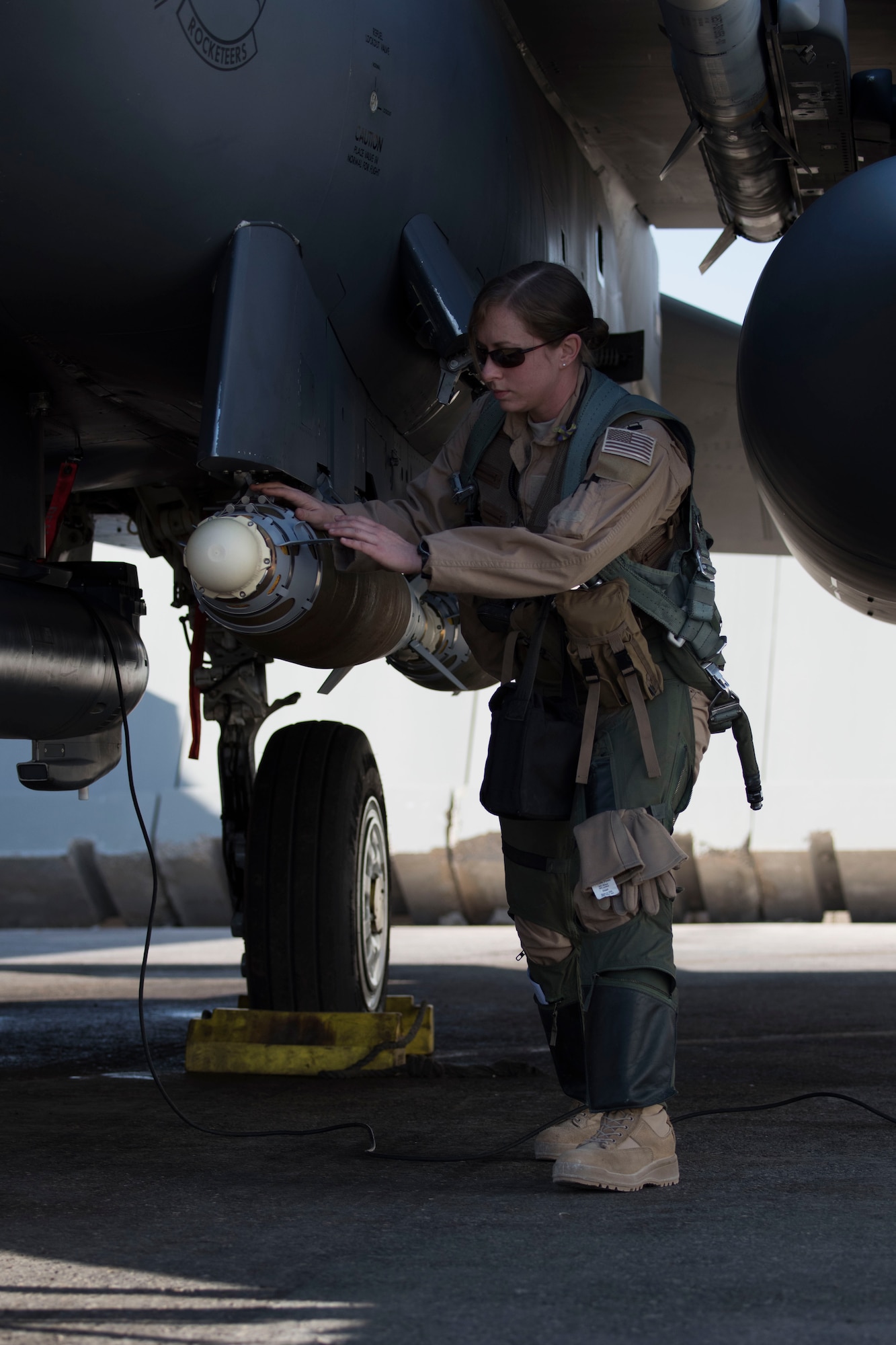 Capt. Jessica Niswonger, 332nd Air Expeditionary Fighter Squadron assistant chief and weapon system officer, examines an F-15E Strike Eagle as part of pre-checks prior to launch March 7, 2018, at an undisclosed location in Southeast Asia.
