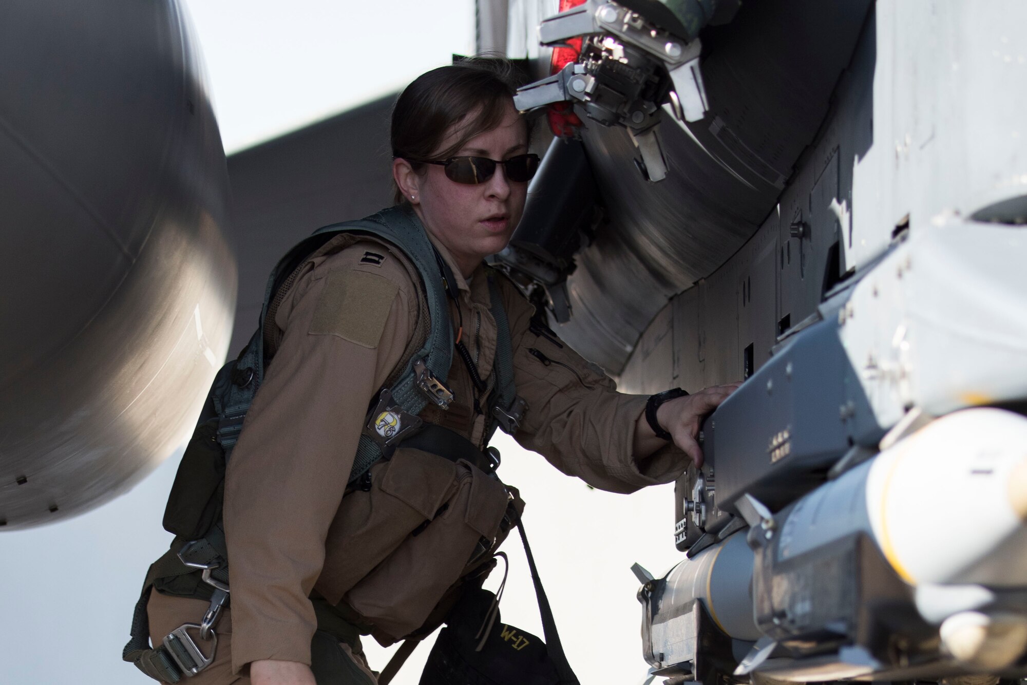 Capt. Jessica Niswonger, 332nd Air Expeditionary Fighter Squadron assistant chief and weapon system officer, examines an F-15E Strike Eagle as part of pre-checks prior to launch March 7, 2018, at an undisclosed location in Southeast Asia.