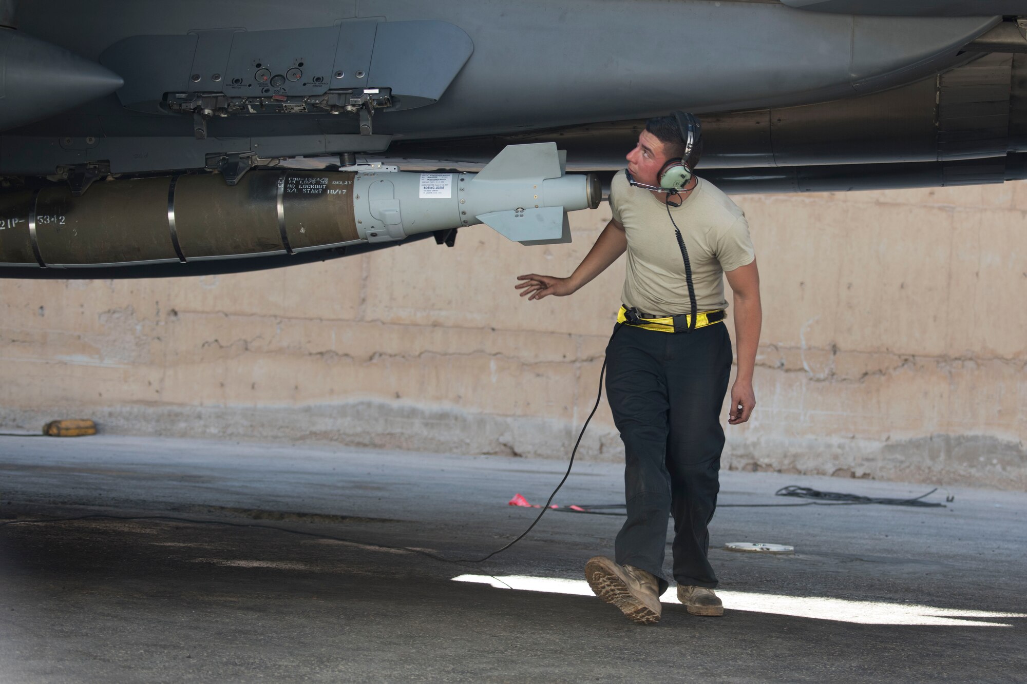 A 332nd Expeditionary Maintenance Squadron crew chief, examines an F-15E Strike Eagle as part of pre-checks for takeoff March 7, 2018, at an undisclosed location in Southeast Asia